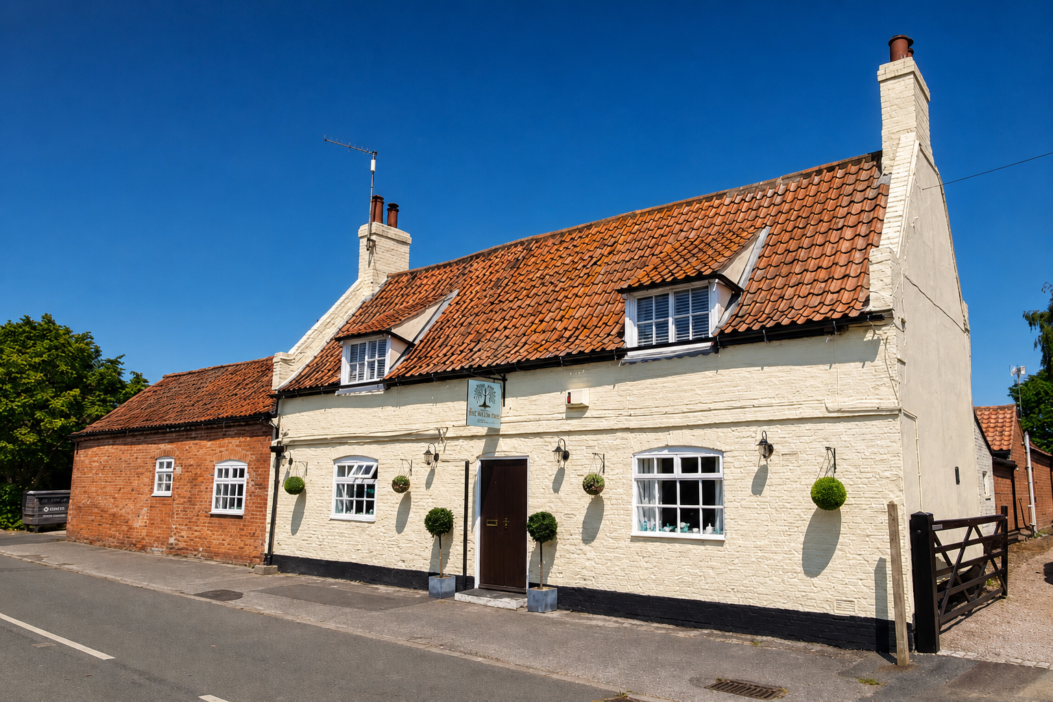 The Willow Tree's whitewashed country pub exterior on Front Street in Barnby in the Willows.